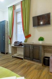 a room with a tv on a wall with curtains at Mini Hotel Barvy Lvova on Horodotska St. in Lviv