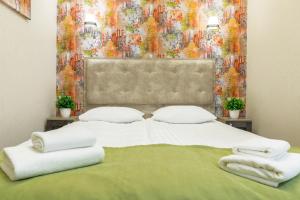 - une chambre avec un grand lit et des serviettes dans l'établissement Mini Hotel Barvy Lvova on Horodotska St., à Lviv