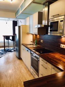 uma cozinha com electrodomésticos em aço inoxidável e pisos em madeira em Ski in/ Ski out Schladming Planai Augasse B8 em Schladming