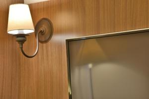a light attached to a wall next to a mirror at Hotel Due Nobili in Gramado