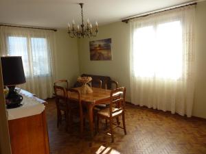 une salle à manger avec une table, des chaises et un lustre dans l'établissement Le cerisier, à Millau