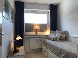 een kleine slaapkamer met een bed en een raam bij Seebrise-Sylt in Westerland