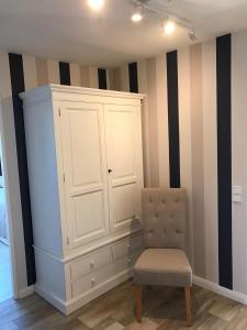 een kamer met een witte kast en een stoel bij Seebrise-Sylt in Westerland