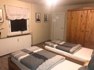 2 camas en una habitación con ventana y armario en Ferienwohnung Stargardt Eimbeckhausen en Bad Münder am Deister