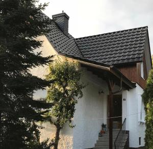 una casa bianca con tetto e scale neri di Ferienwohnung Stargardt Eimbeckhausen a Bad Münder am Deister