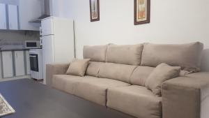 a brown couch in a kitchen with a white refrigerator at Apartamentos la Bastida in Totana