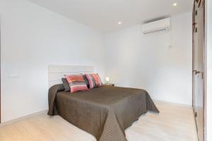 ein Schlafzimmer mit einem Bett in einem weißen Raum in der Unterkunft Villa Can Carreras in Sant Llorenç de Balàfia