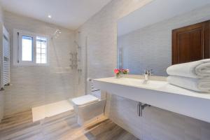 ein weißes Badezimmer mit Waschbecken und Dusche in der Unterkunft Villa Can Carreras in Sant Llorenç de Balàfia
