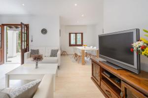 ein Wohnzimmer mit einem großen Flachbildfernseher in der Unterkunft Villa Can Carreras in Sant Llorenç de Balàfia + 26 Fotos