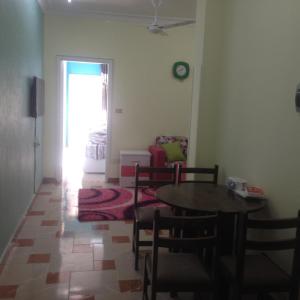 un soggiorno con tavolo e sedie e una camera da letto di Sweet Home Flat 2 a Hurghada