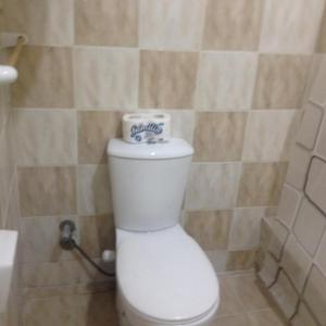 a toilet with a roll of toilet paper on top of it at Sweet Home Flat 2 in Hurghada