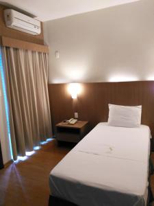 Ένα ή περισσότερα κρεβάτια σε δωμάτιο στο Sete Lagoas Residence Hotel