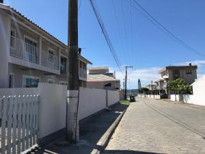 an empty street with a white fence and a pole at Apartamento Sunset 101 in Palhoça