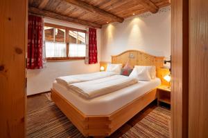 ein Schlafzimmer mit einem großen Bett in einem Zimmer in der Unterkunft Almdorf Flachau - Luxus Hüttenurlaub in Flachau