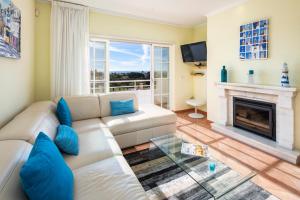 a living room with a white couch and a fireplace at Casa Atlantida Golfemar in Carvoeiro