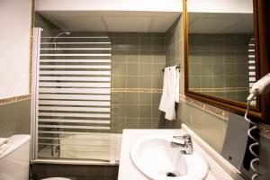 y baño con lavabo, espejo y ducha. en Bed and Snow Art Apartments, en Sierra Nevada