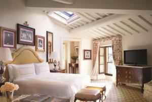 a bedroom with a white bed and a television at Four Seasons Hotel Firenze in Florence