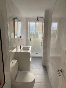 馬德里的住宿－Apartamento situado a 10 minutos de opera，白色的浴室设有卫生间和水槽。
