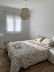 a white bedroom with a bed with a comforter at Apartamento situado a 10 minutos de opera in Madrid