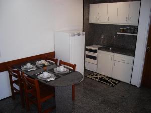 a small kitchen with a table and a refrigerator at Vip Iracema Flat in Fortaleza
