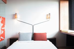 a bedroom with a white bed with two pillows at Volkshotel in Amsterdam