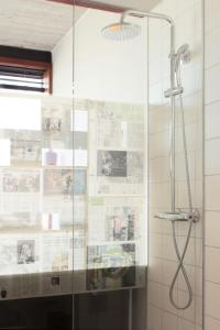 a shower with a glass door in a bathroom at Volkshotel in Amsterdam