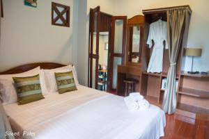 Un dormitorio con una cama y un vestido en un estante en Silent Palm Samui, en Taling Ngam