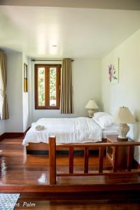 Un dormitorio con una cama grande y una ventana en Silent Palm Samui en Taling Ngam Beach
