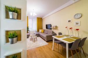 sala de estar con sofá y mesa en una habitación en Apartament Wietora WAWELOFTS en Cracovia