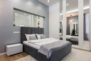 - une chambre avec un grand lit et un miroir dans l'établissement Royal Apartment on Franka 28, à Lviv