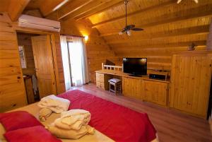 1 dormitorio con 1 cama y TV en una cabaña en Rancho Paradise - Adults Only en Nono