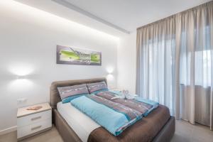 um quarto com uma cama e uma grande janela em Fior Apartments Schiller em Merano