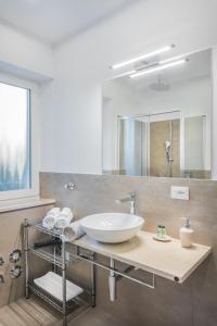 y baño con lavabo y espejo. en Fior Apartments Schiller en Merano