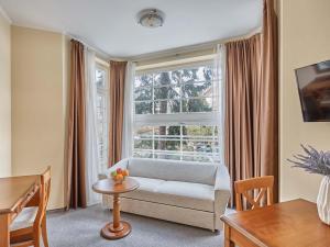 a living room with a couch and a large window at Akropolis Apart Hotel in Karlovy Vary