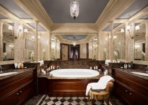 モンテカルロにあるHôtel Métropole Monte-Carloの浴槽と2つの洗面台を備えた広いバスルーム