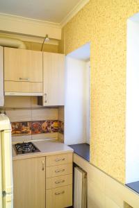 a kitchen with wooden cabinets and a stove top oven at Apartment in the city center Tsytadelnaya 7 in Kyiv