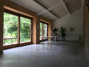 een kamer met ramen en een tafel en twee personen bij B&B De Henehoeve in Heks