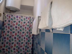 a shower curtain in a bathroom with blue tiles at Sweet Stay Home in Rome