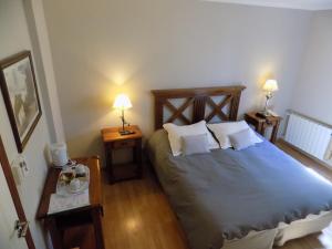 a bedroom with a bed with two night stands and two lamps at Hostería Patagonia Jarke in Ushuaia