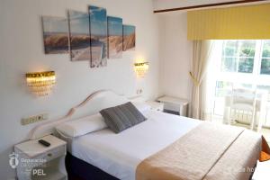 ein Schlafzimmer mit einem weißen Bett und einem Fenster in der Unterkunft Hotel Alda Santa Cristina in Perillo