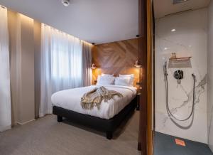 a hotel room with a bed and a shower at 9Hotel Paquis in Geneva