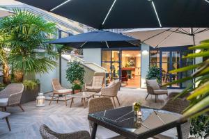 米蘭的住宿－Magville，一个带桌椅和遮阳伞的庭院