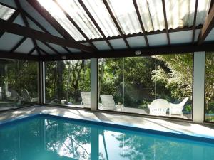 - une piscine avec des chaises blanches dans l'établissement Pousada do Pescador, à Florianópolis