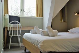
a bedroom with a bed and a chair at Hotel Light in Rotterdam
