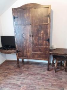 a wooden cabinet in a room with a table at HANUL TENTEA in Săcel