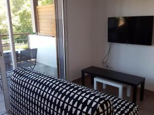 een woonkamer met een bank en een flatscreen-tv bij Terres Marines in Saint-Jean-de-Luz