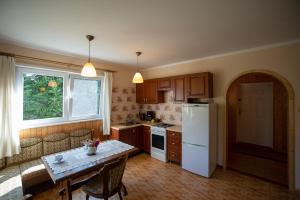 a kitchen with a table and a white refrigerator at Rydzewo Zacisze Domek Całoroczny in Rydzewo