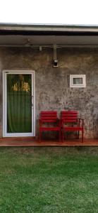 two red benches sitting next to a building with green grass at Koh Mak Homestay in Ko Mak