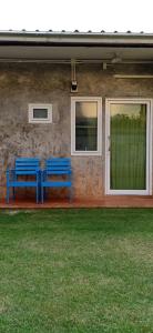 two blue benches sitting in front of a house at Koh Mak Homestay in Ko Mak