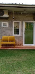 a yellow bench sitting on the front of a house at Koh Mak Homestay in Ko Mak